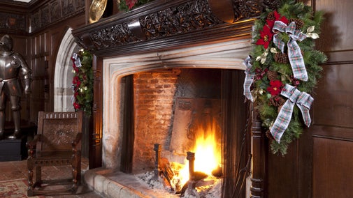 A cosy fire burning in the hearth at Ightham Mote's Great Hall